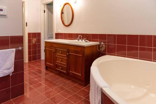 ein Badezimmer mit einer Badewanne und einem Waschbecken in der Unterkunft Furche Barossa Vineyard Family Stay 