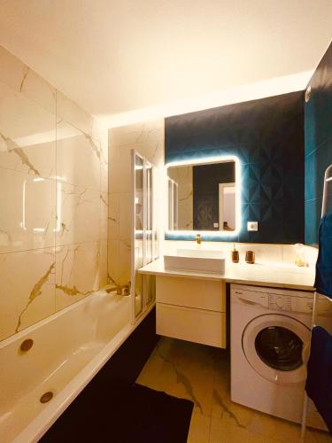une salle de bain avec un lavabo et une machine à laver dans l'établissement La montagne ça vous gagne !, à Cluses