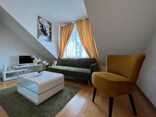 a living room with a couch and a chair at Cosy apartment in central location in Vienna