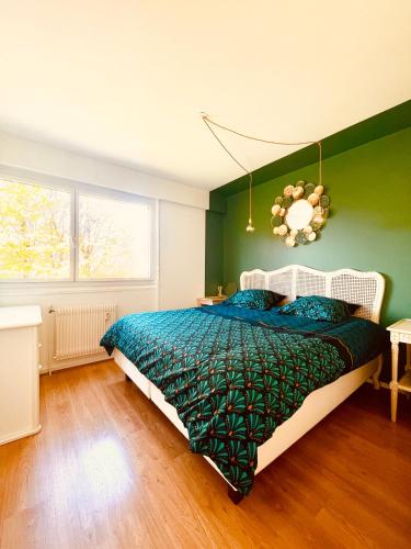- une chambre dotée d'un lit avec un mur vert dans l'établissement La montagne ça vous gagne !, à Cluses