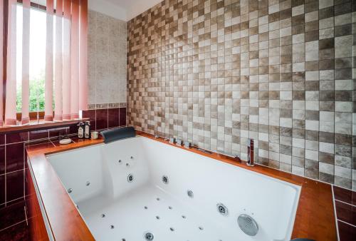 y baño con bañera grande y azulejos. en Villa Riga, en Mārupe