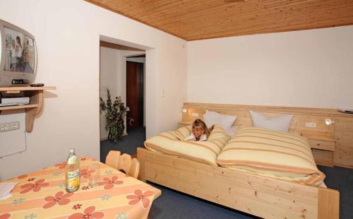 施皮格勞的住宿－Hotel-Pension Würzbauer，躺在卧室床上的女人