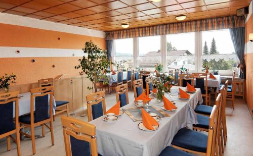 a dining room with a long table and chairs at Hotel-Pension Würzbauer in Spiegelau