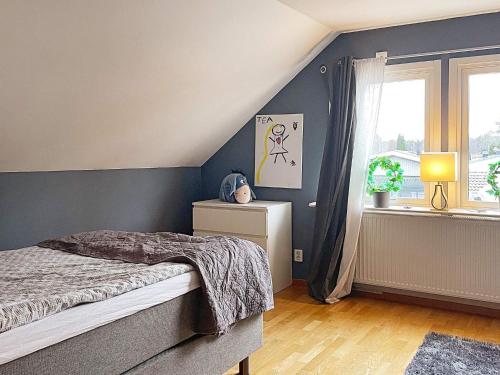 a bedroom with blue walls and a bed and a window at Holiday home Björklinge in Björklinge