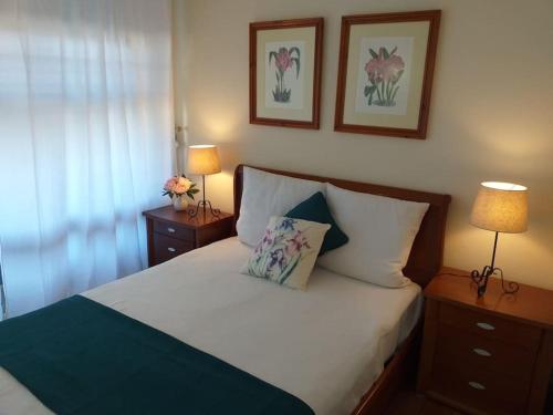 a bedroom with a bed with two lamps and flowers on it at Relax Beach Home - Costa de Caparica - Sea View in Costa da Caparica