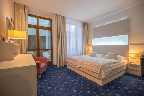 リトミシュルにあるHotel Zlatá Hvězdaのベッドと椅子付きのホテルルーム