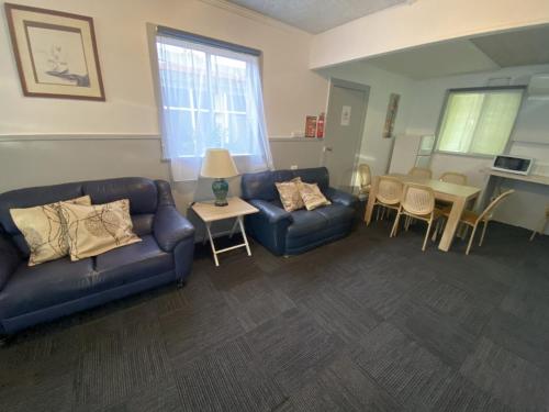 a living room with two couches and a table and chairs at Charlton Motel in Charlton