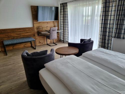 ein Hotelzimmer mit 2 Betten, einem Tisch und Stühlen in der Unterkunft Hotel Beinbauer in Büchlberg