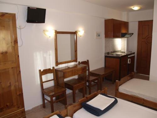 Habitación pequeña con cama y espejo. en Hotel Kosmas, en Sarti