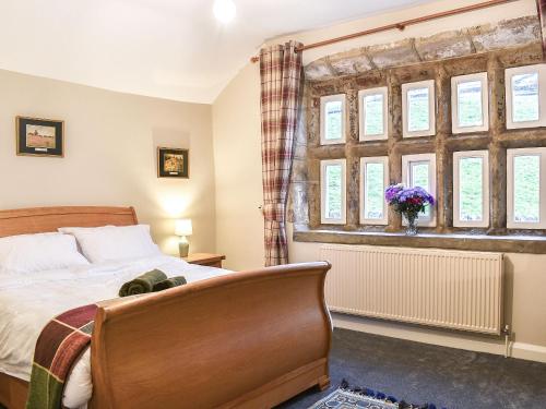 1 dormitorio con cama y ventana en Newlands Farm Cottage Halifax, en Luddenden Foot