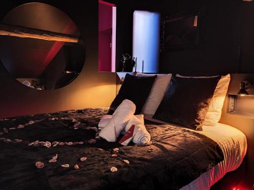 una camera con un grande letto e uno specchio di Suite Privative Rouge baiser - Spa & Jacuzzi - Love Room à Saint Etienne a Saint-Étienne