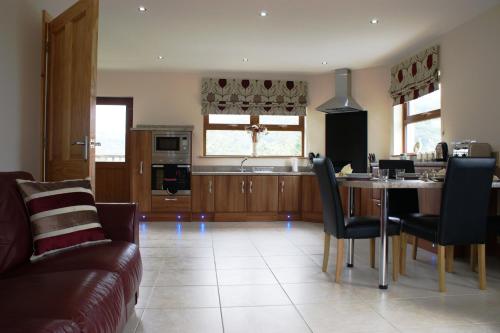 a kitchen and living room with a table and chairs at Glendun Self Catering in Cushendall