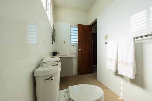 a white bathroom with a toilet and a sink at La Esmeralda PR in San Juan