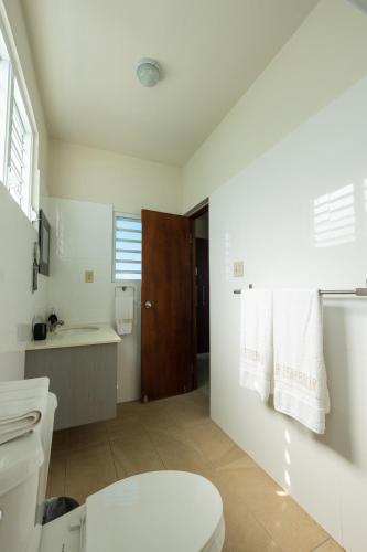 a bathroom with a toilet and a sink at La Esmeralda PR in San Juan