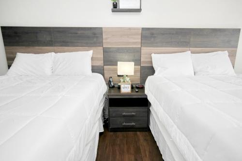 two beds in a room with a nightstand between them at Landmark Resort 1208 in Myrtle Beach