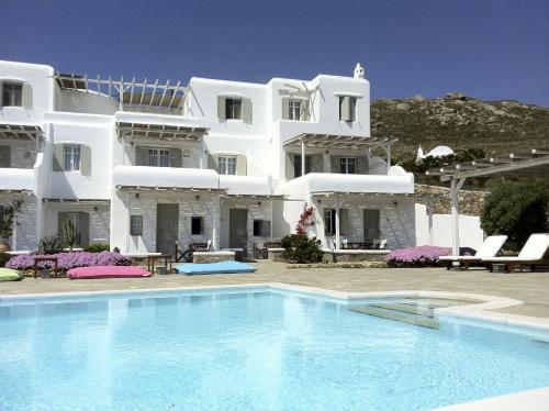 a large white house with a swimming pool in front of it at Yakinthos Residence in Panormos Mykonos