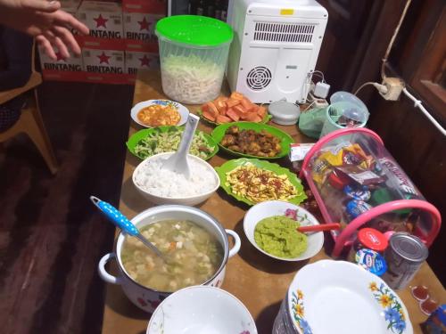 a table with many different dishes of food on it at Home stay wolokoro ecotourism in Bajawa