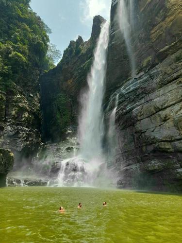 people swimming in a pool in front of a waterfall at Water Side Residence in Adams Peak