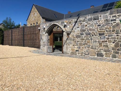a stone building with a door in the side of it at Aux Portes de Durbuy in Clavier