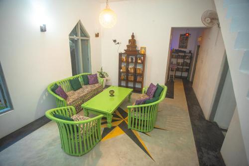 a living room with a green table and chairs at Percy Residence in Unawatuna