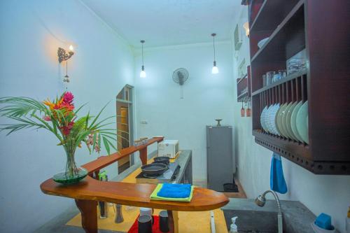 a kitchen with a table with a vase of flowers on it at Percy Residence in Unawatuna