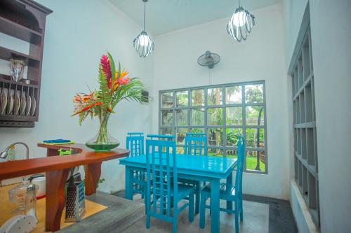 a dining room with blue chairs and a blue table at Percy Residence in Unawatuna