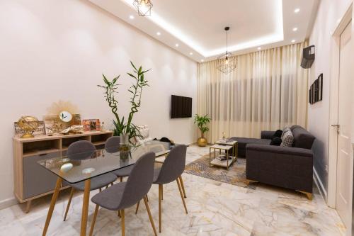 a living room with a table and chairs and a couch at Airport Apartment Suite Casablanca FREE WIFI Modern Confort Calme in Derroua
