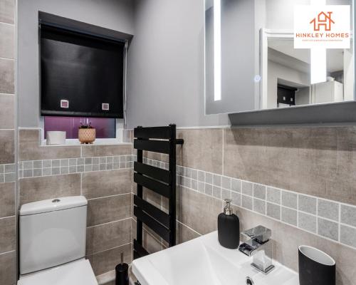 een badkamer met een toilet, een wastafel en een spiegel bij 2 Bedroom House Liverpool- Large & Cosy- Sleeps 5 By Hinkley Homes Short Lets & Serviced Accommodation in Liverpool
