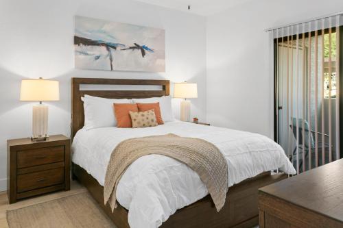 a bedroom with a bed with white sheets and orange pillows at The Nines Scottsdale in Scottsdale