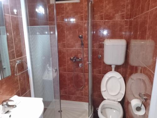uma casa de banho com um chuveiro, um WC e um lavatório. em Mili Host em Belgrado