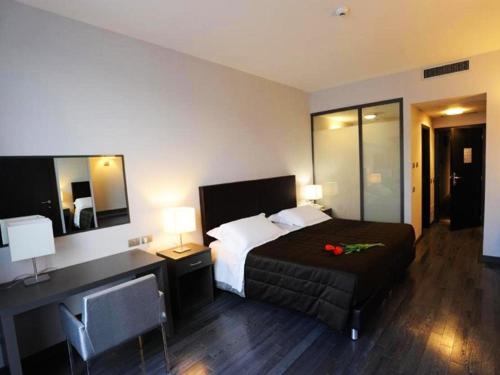 a hotel room with a bed and a desk with a bed sidx sidx sidx at Park Hotel Sporting in Teramo