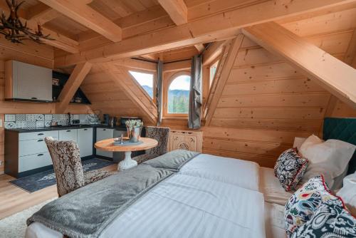 1 dormitorio en una cabaña de madera con 1 cama y 1 mesa en Rich Witch Villa&SPA, en Kościelisko