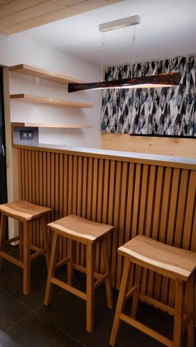 two tables and two stools in front of a bar at Tri borovice in Liptovský Mikuláš