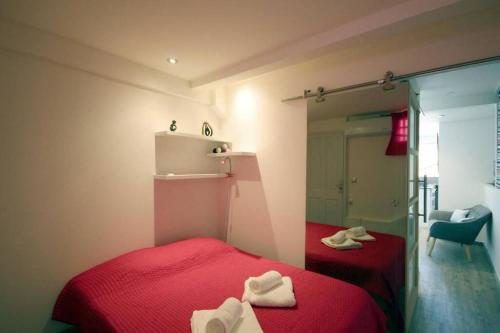 - une chambre avec un lit rouge et un miroir dans l'établissement T2 design pour 2 à Anse à l'Âne aux Trois Ilets, à Les Trois-Îlets
