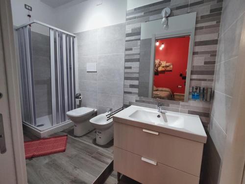 a bathroom with a sink and a toilet and a mirror at The Junior House - Casa Vacanza in Lauria Inferiore