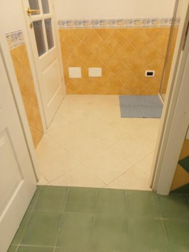 a bathroom with a shower and a tiled floor at B&B Il Sentiero in San Sperate
