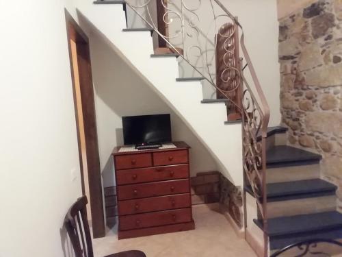 una scala con un comò con un televisore in cima di Casa vacanza da Rosy a Gonnosfanàdiga