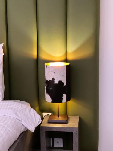 a lamp on a night stand next to a bed at Les Trois Chaufatons - Chalets Boutiques in Montriond