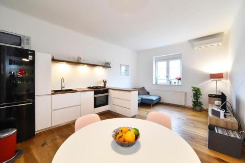 a kitchen with a table with a bowl of fruit on it at Cosy Lu Apartment in Zagreb