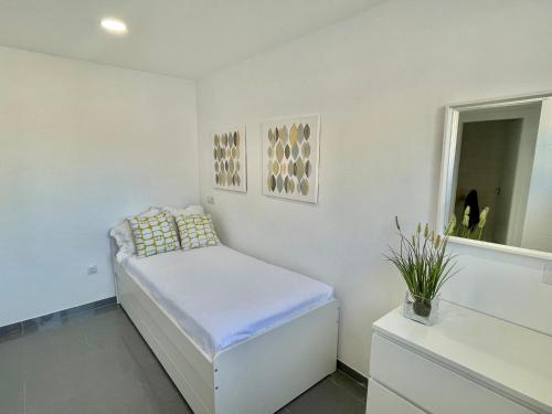 a white room with a bed and a mirror at The Retreat House - Private Pool in Puerto de Santiago