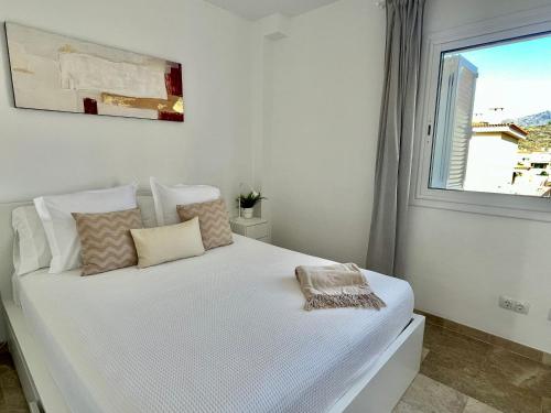 a bedroom with a white bed with a window at The Retreat House - Private Pool in Puerto de Santiago