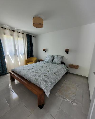 a bedroom with a bed in a room with windows at Le Refuge d'Heva in Salazie