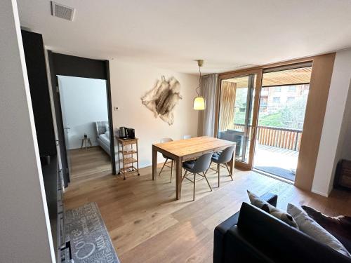a living room with a dining room table and a couch at Beautiful Sunny New 1 Bed Apt (2.5Zim). Ski in/out in Flims