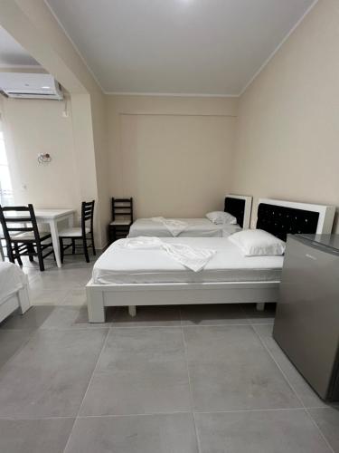 a bedroom with a bed and a table and chairs at Harmony Apartments in Sarandë