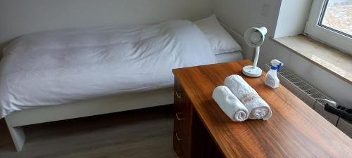 ein Schlafzimmer mit einem Bett und einem Holztisch mit Handtüchern in der Unterkunft Hanover Fair Rooms in Hannover