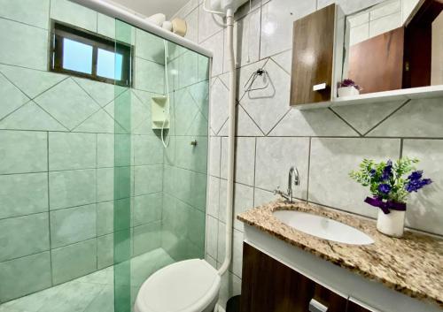y baño con aseo, lavabo y espejo. en Paraíso em Bombas rua Rouxinol, en Bombinhas