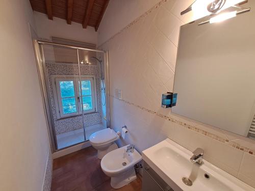 ein Badezimmer mit einem WC, einem Waschbecken und einem Spiegel in der Unterkunft Casa Daria, Armonia del Passato nel rispetto della natura in Donoratico