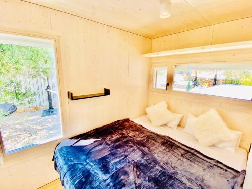 uma cama num pequeno quarto com uma janela em BUQEZ ECO RESORT - Beach Villa 28 - Directly by beach em Drage