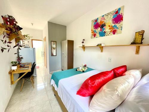 a bedroom with two red pillows on a bed at Vila Vasconcelos in Itacaré