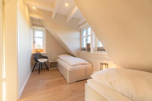Cette petite chambre mansardée comprend un lit et un bureau. dans l'établissement Hus Sünneck, à Wyk auf Föhr